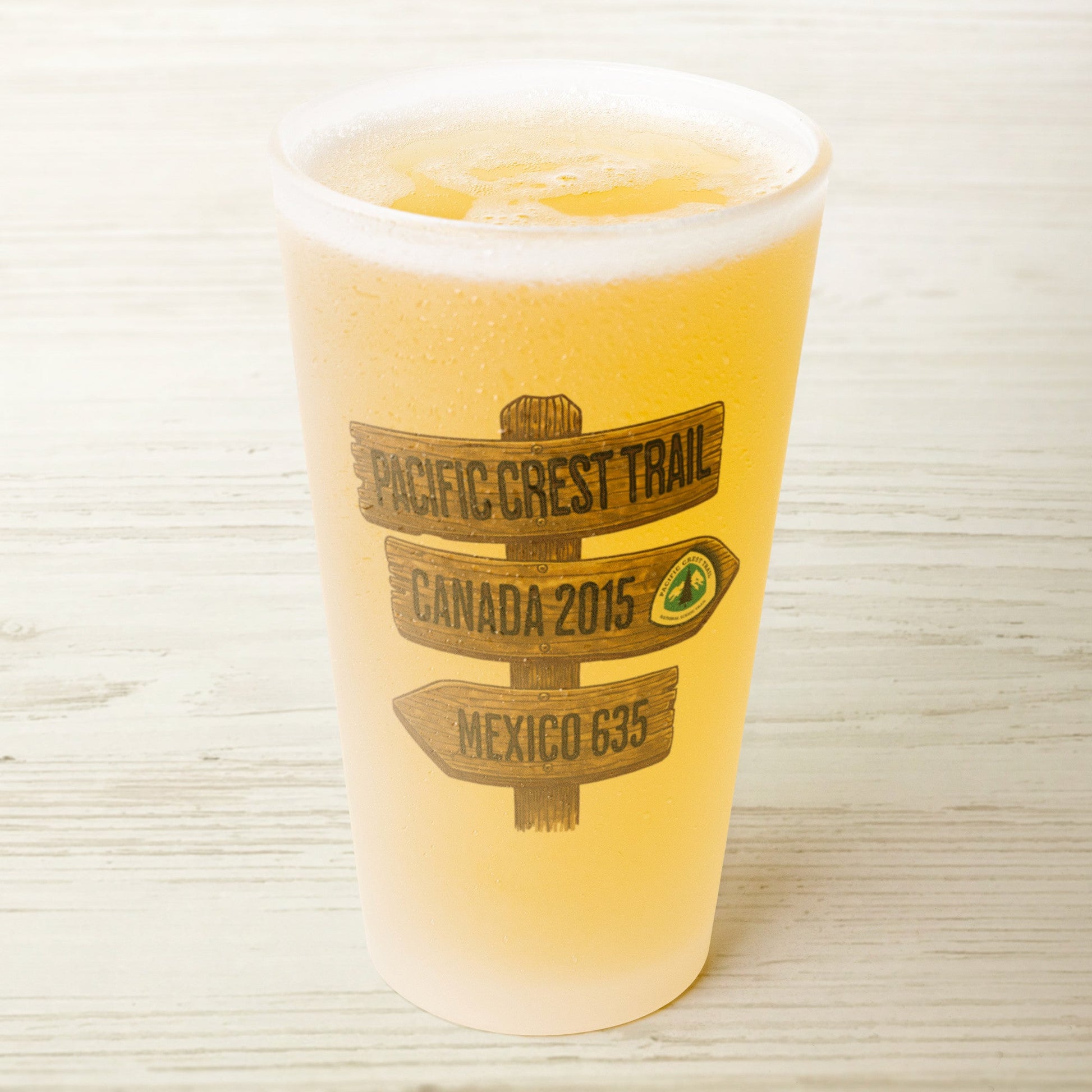 Pacific Crest Trail mileage sign frosted pint glass shown from alternate product angle