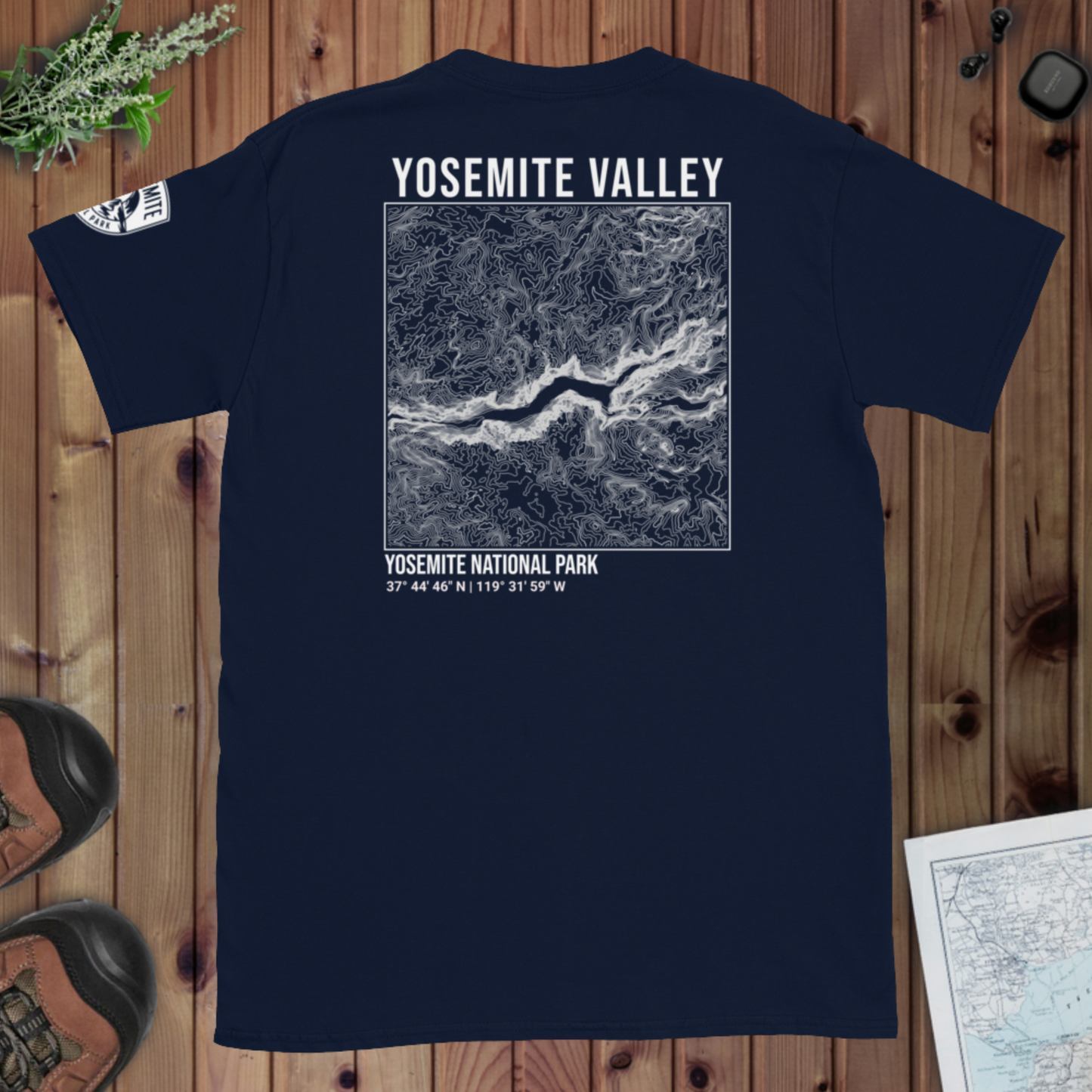 Navy blue t-shirt with Yosemite Valley map design on a wooden surface