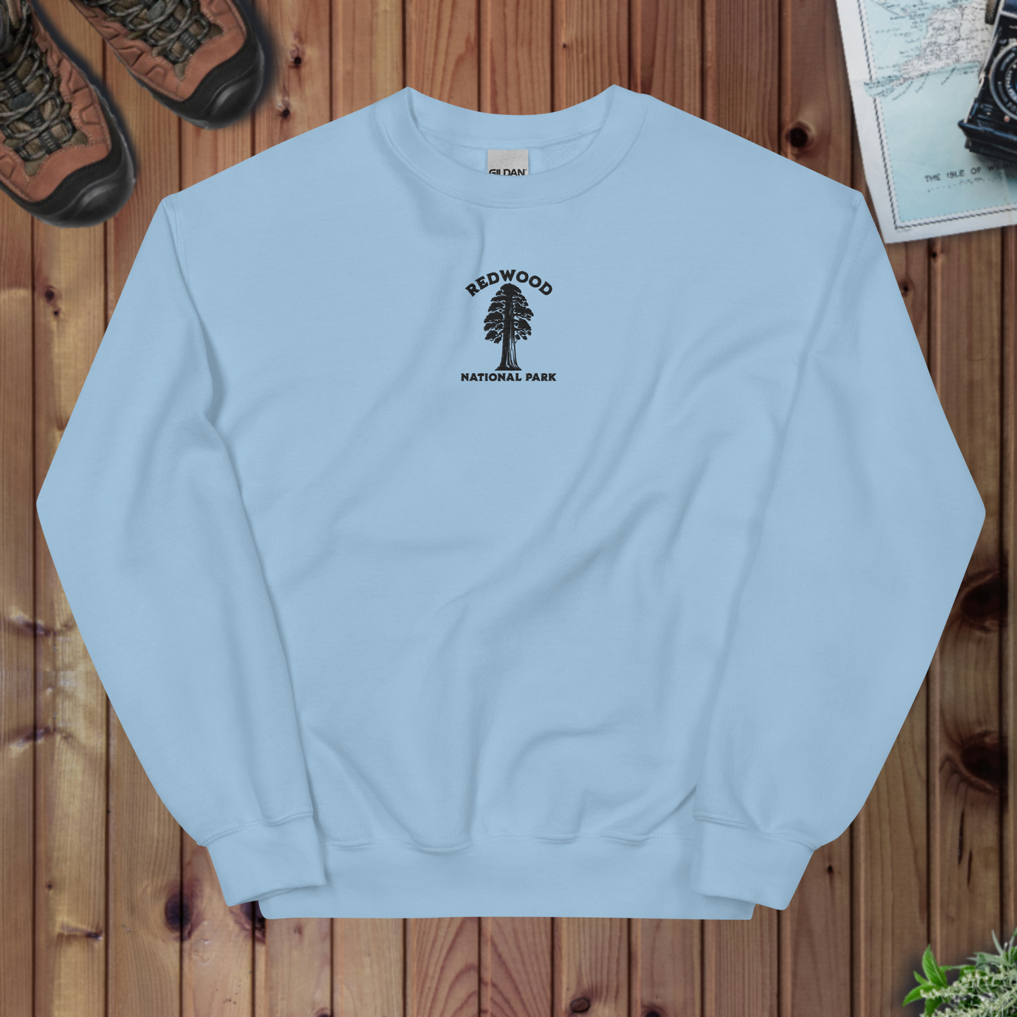Light blue sweatshirt with Redwood National Park logo on a wooden surface