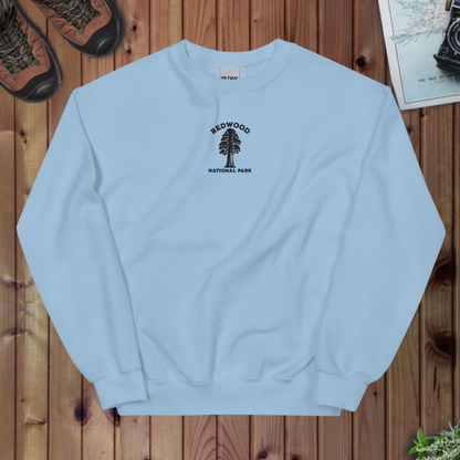 Light blue sweatshirt with Redwood National Park logo on a wooden surface