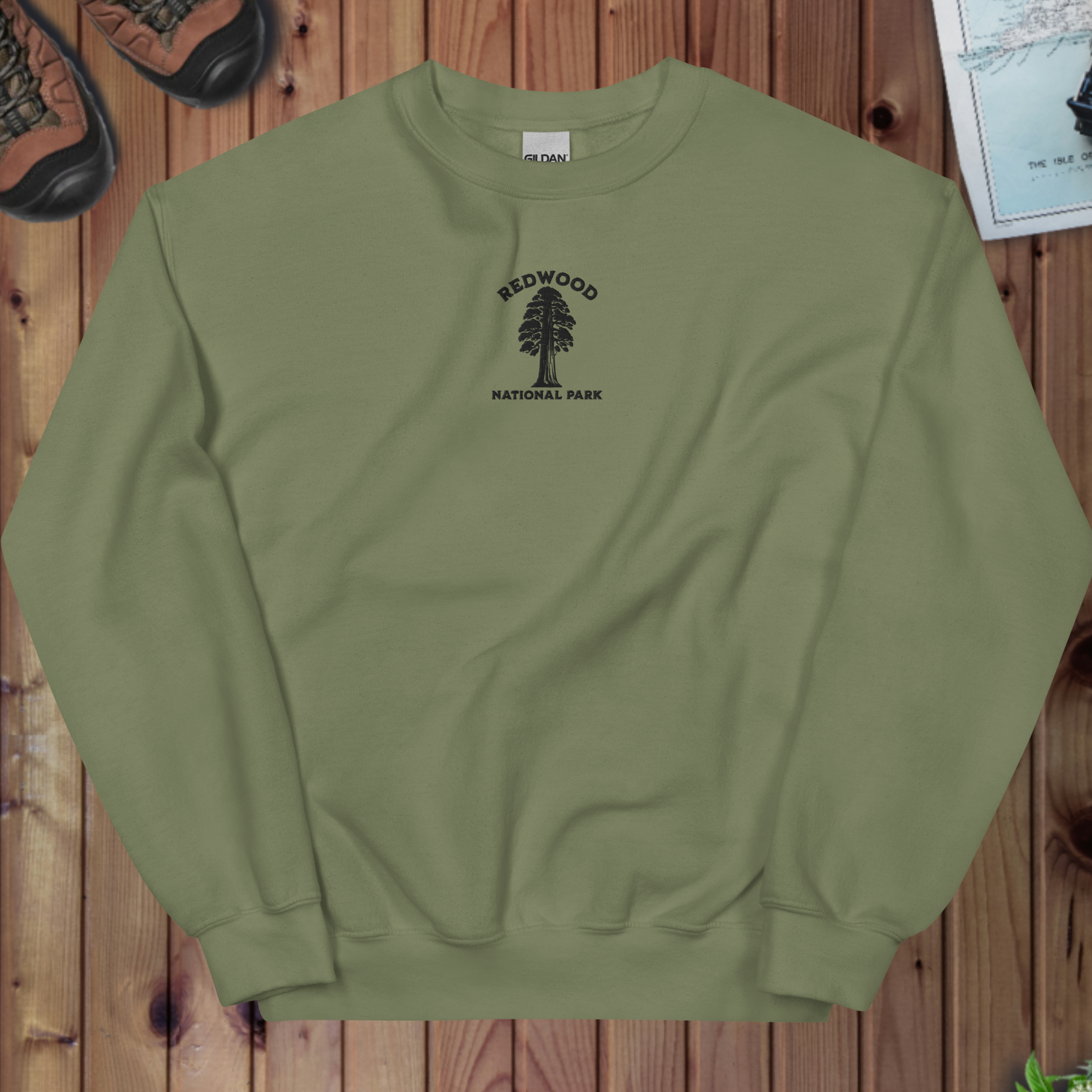 Green sweatshirt with Redwood National Park logo on a wooden surface