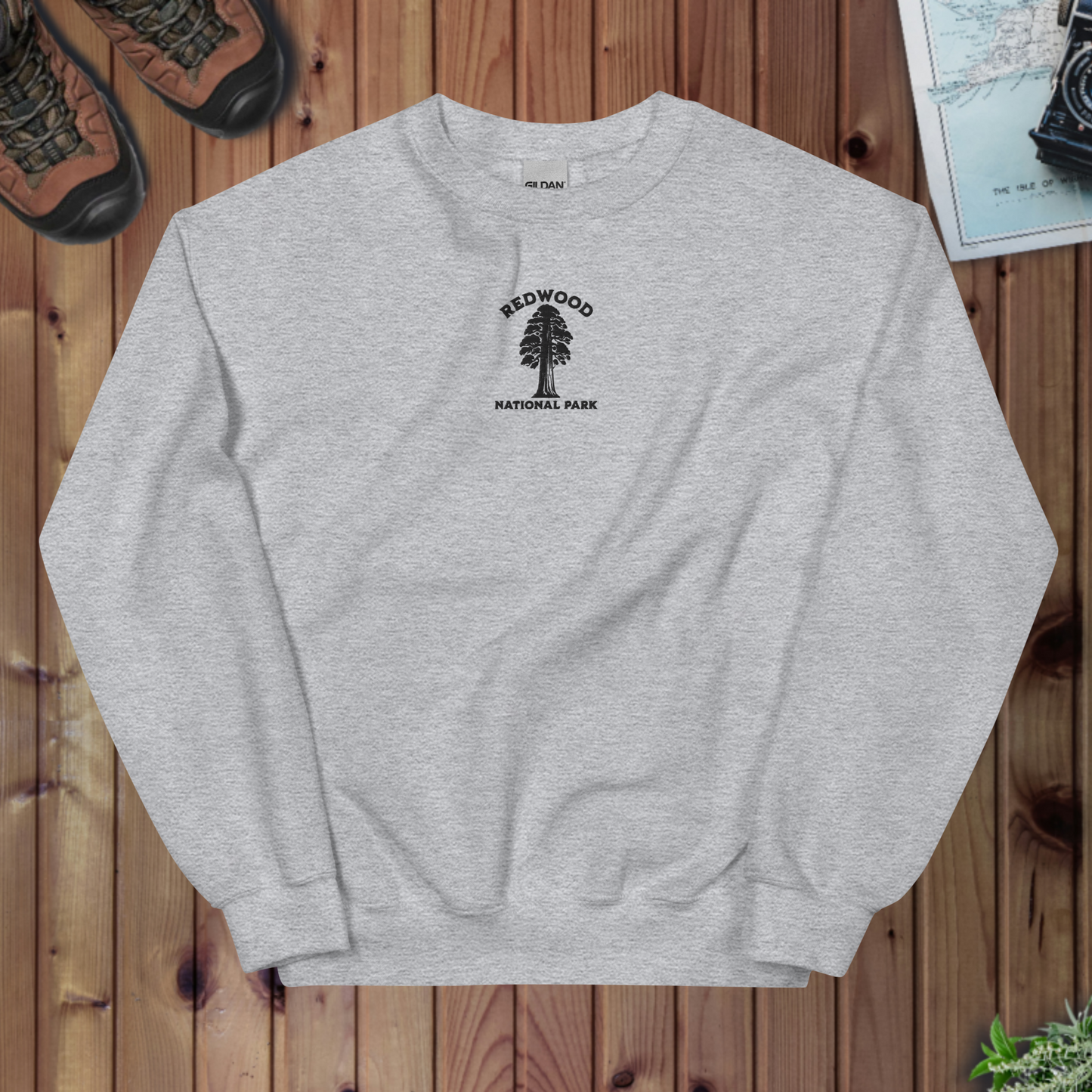Gray sweatshirt with Redwood National Park logo on a wooden surface