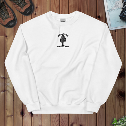 White sweatshirt with Redwood National Park logo on a wooden surface
